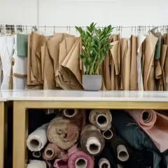 Atelier de couture avec patrons en papier et rouleaux de tissu, dont du polyester tissu, prêts à être transformés.