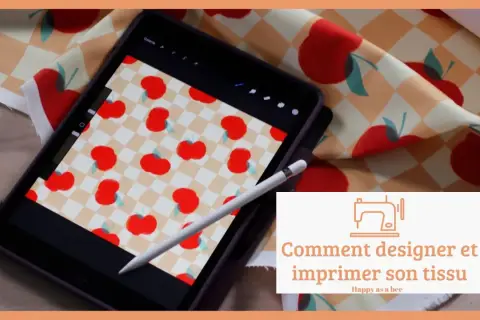 Un dessin sur tissu motif de pommes rouges sur fond à carreaux, visible sur une tablette et un échantillon de tissu.