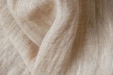 Texture naturelle du lin, évoquant la douceur et la qualité de sa fabrication.