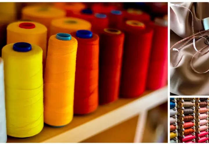 Bobines de fil métallique utilisé dans les textiles, aux couleurs vives. Un mètre ruban et des ciseaux sur un tissu rose pâle.