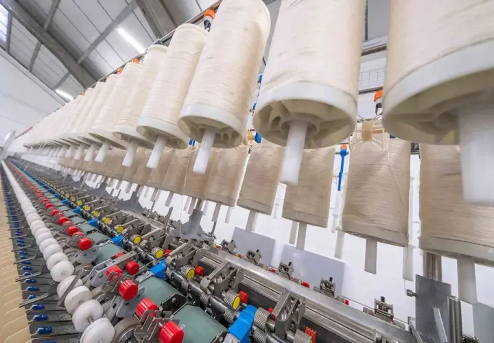 Machine à filer le lin en France, avec de grands rouleaux de fil prêts à être transformés.