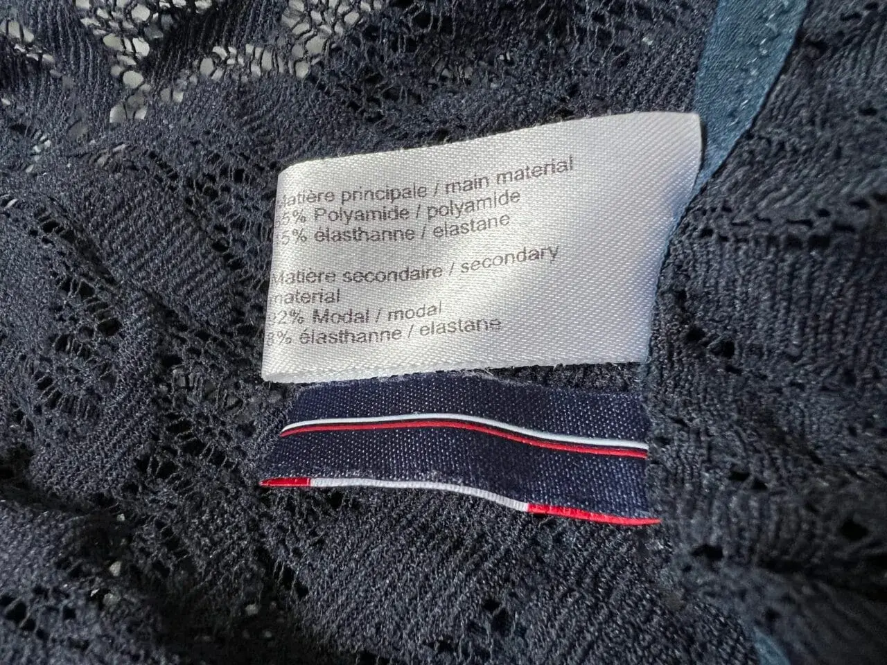 Étiquette de composition : 65% polyamide, 15% élasthanne. Le polyamide, c'est quoi ? Une fibre synthétique résistante et souple.