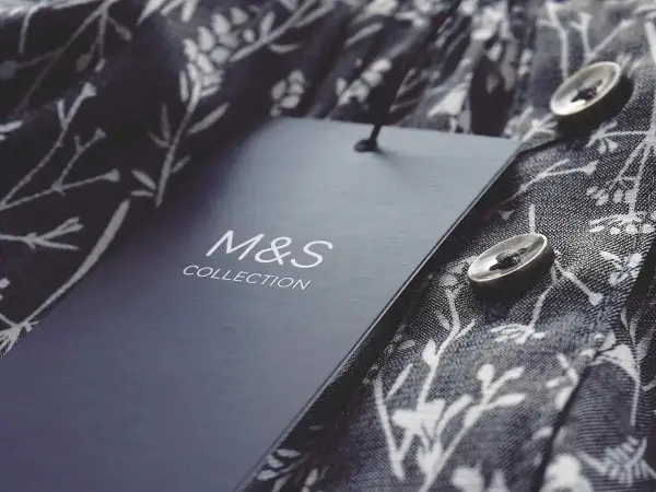 Étiquette M&S Collection sur un tissu fleuri. Astuce pour savoir comment décoller une étiquette sans l'abimer.